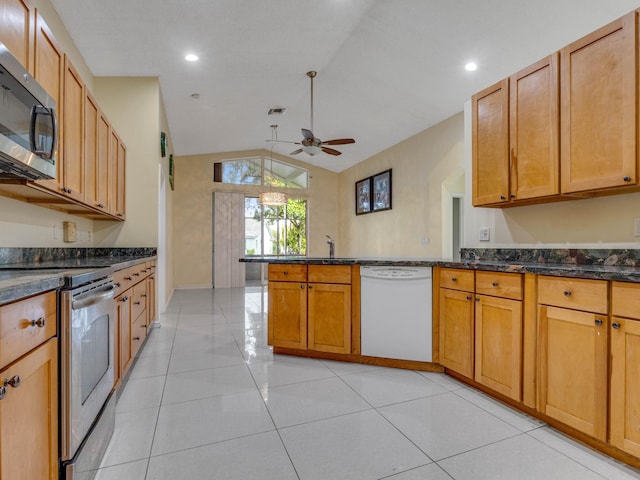 kitchen with vaulted ceiling, kitchen peninsula, appliances with stainless steel finishes, and light tile patterned flooring