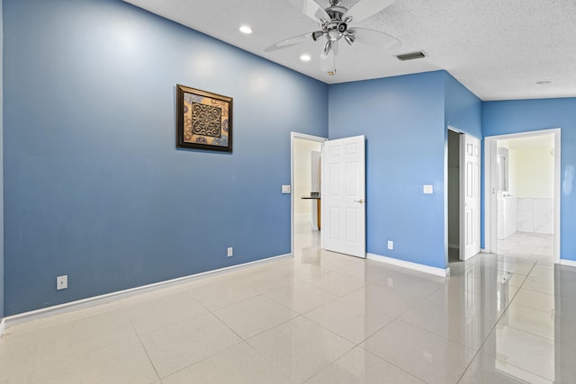 spare room featuring vaulted ceiling, ceiling fan, light tile patterned floors, and a textured ceiling