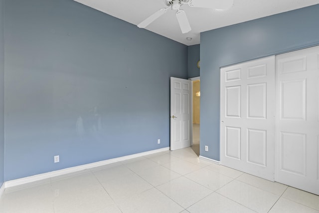 unfurnished bedroom with light tile patterned flooring, a closet, and ceiling fan