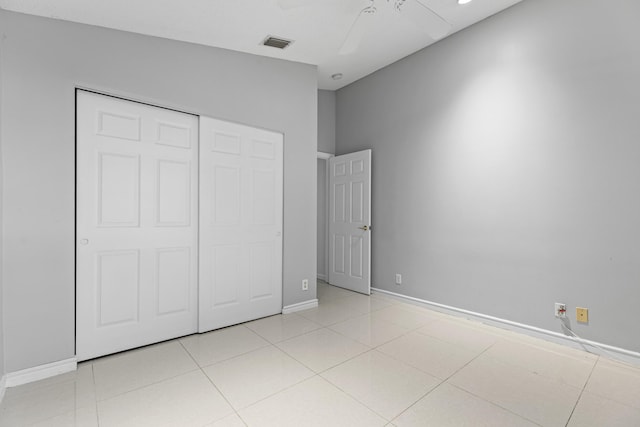 unfurnished bedroom with ceiling fan, light tile patterned floors, and a closet