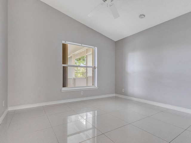 tiled spare room with ceiling fan and vaulted ceiling