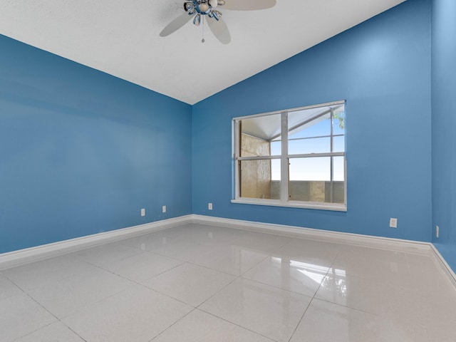 tiled empty room with ceiling fan and lofted ceiling