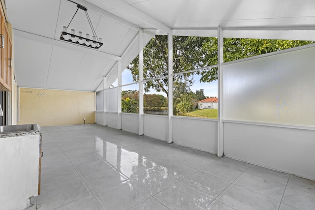 unfurnished sunroom with vaulted ceiling with beams