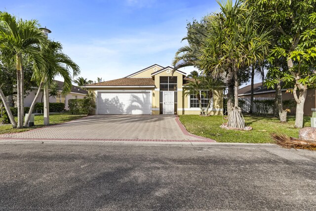 1784 Sawgrass Cir, Greenacres, FL 33413 - view of front of property with decorative driveway, a garage, stucco siding, and a front yard