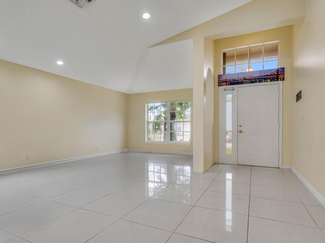 tiled entryway featuring high vaulted ceiling