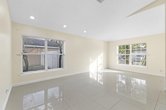 tiled spare room with a textured ceiling