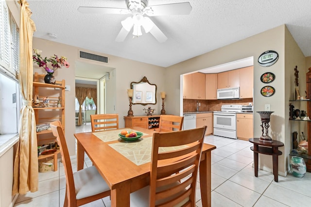 dining space featuring ceiling fan, a textured ceiling, and light tile patterned floors