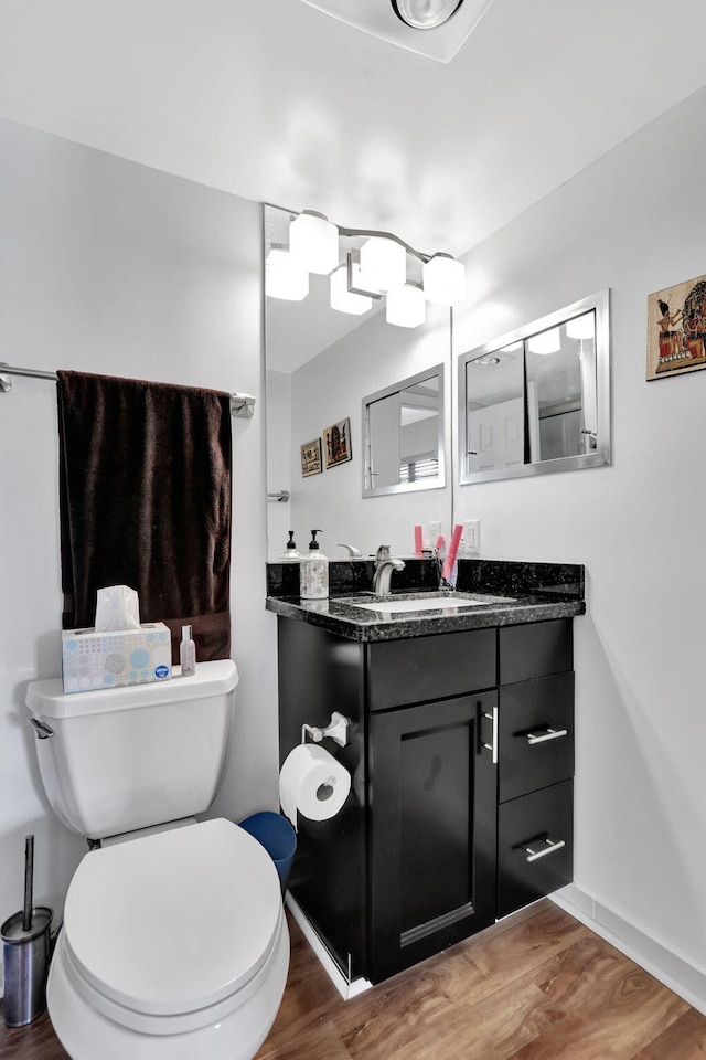 bathroom featuring vanity, wood-type flooring, and toilet