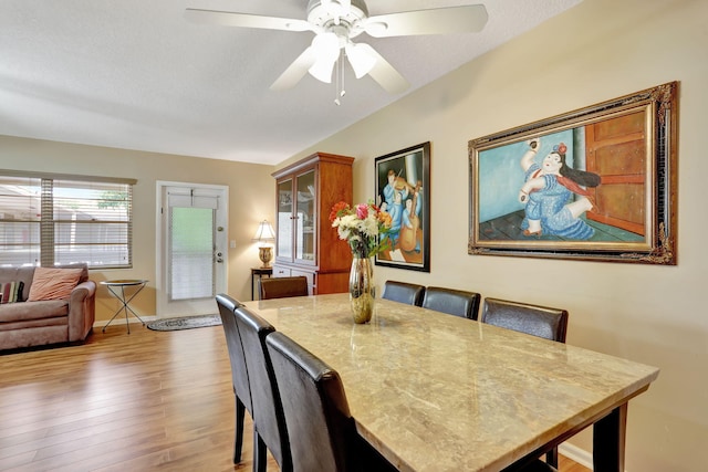 dining area with hardwood / wood-style flooring, ceiling fan, and a textured ceiling