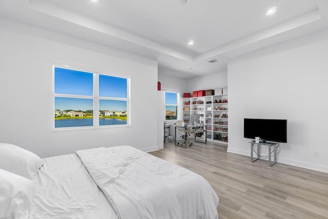 bedroom featuring a raised ceiling and hardwood / wood-style floors