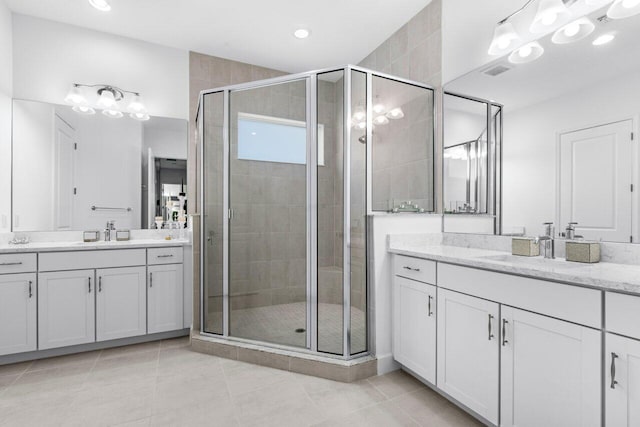 bathroom with tile patterned flooring, a shower with shower door, and vanity