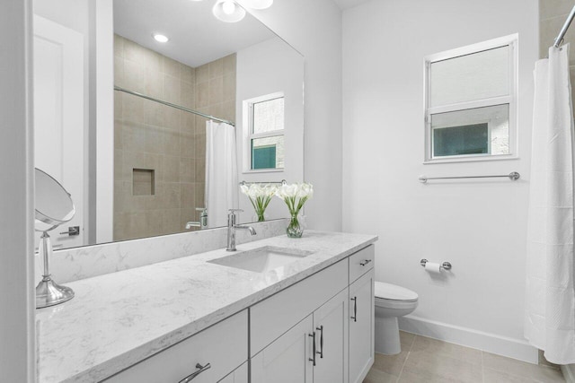 bathroom with toilet, vanity, tile patterned flooring, and walk in shower