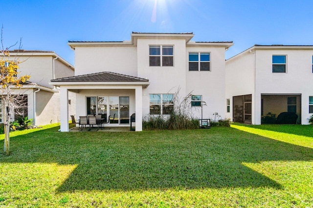 rear view of house featuring a patio and a yard