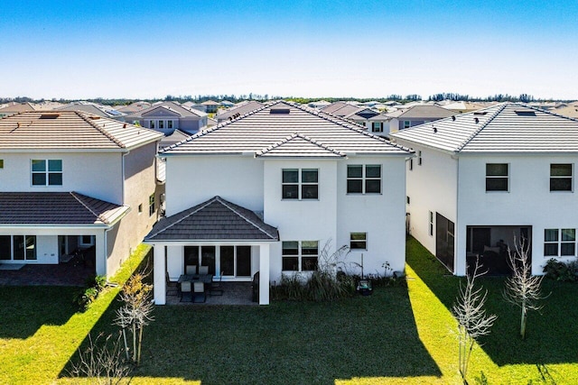 rear view of property with a lawn and a patio