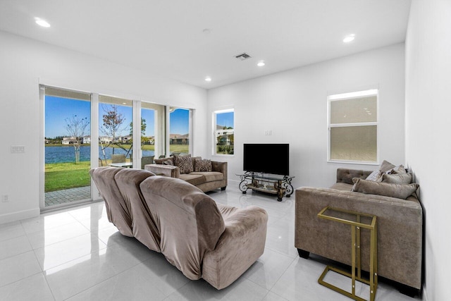 living room with light tile patterned flooring and a water view