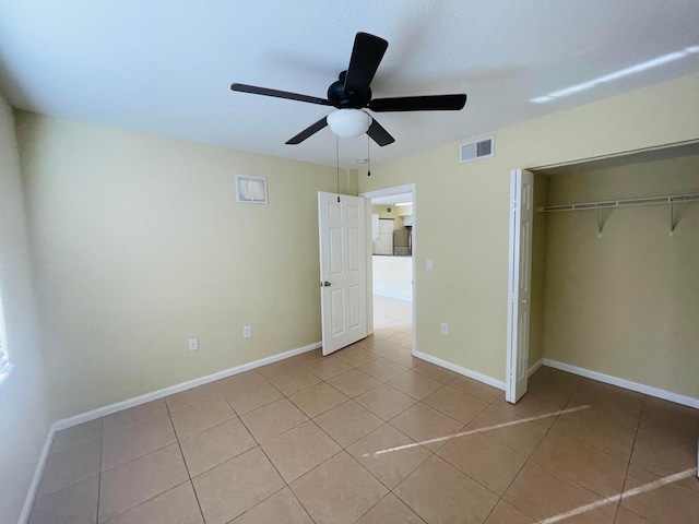 unfurnished bedroom featuring ceiling fan, a closet, and light tile patterned floors