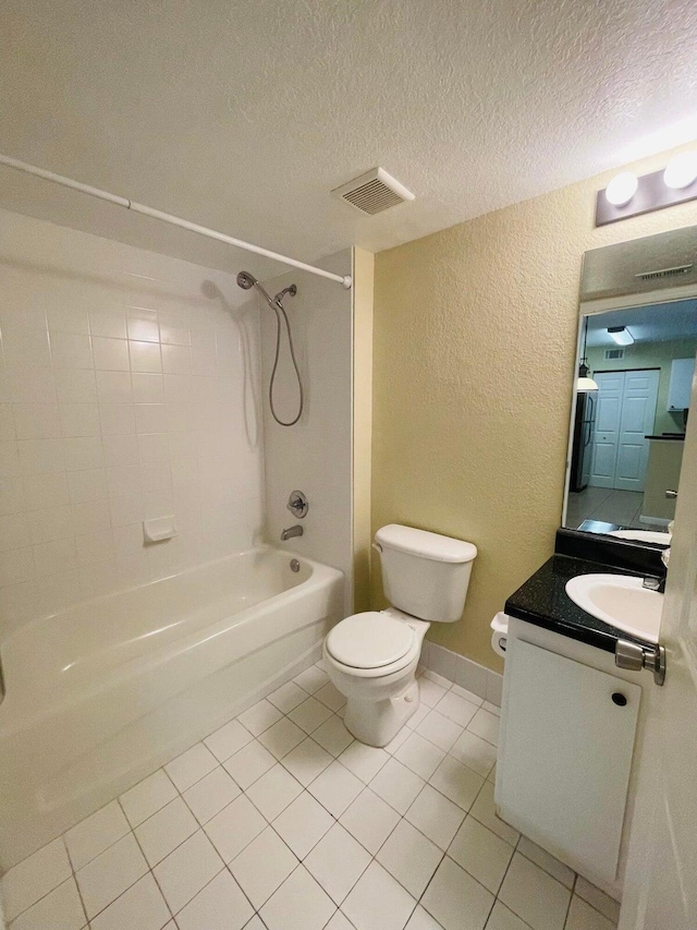 full bathroom featuring a textured ceiling, tile patterned flooring, toilet, vanity, and tiled shower / bath combo