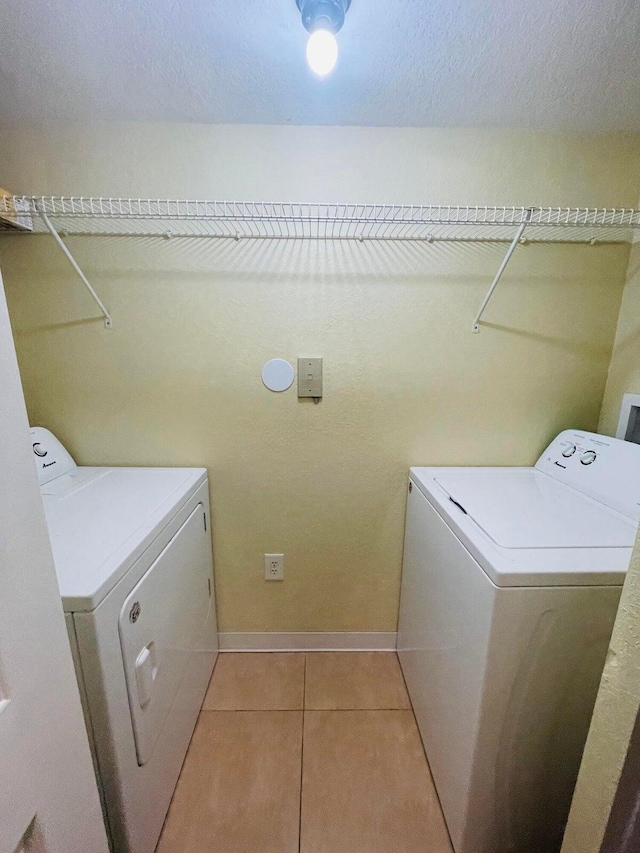 laundry area with washer and dryer and light tile patterned flooring