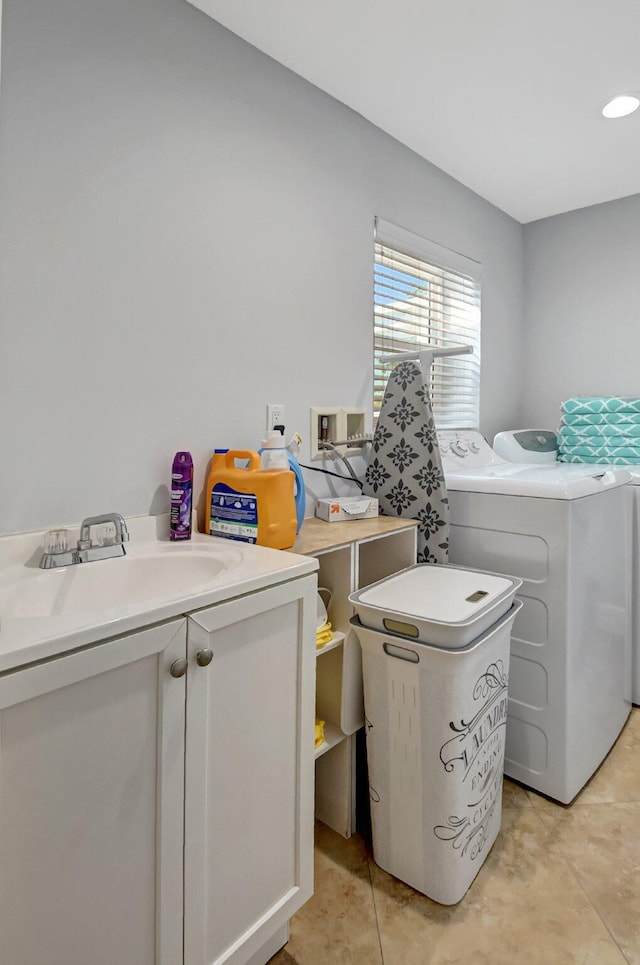 washroom with separate washer and dryer, cabinets, sink, and light tile patterned floors