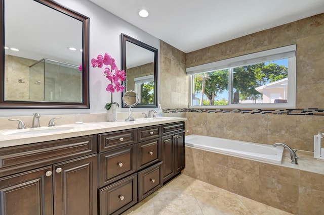 bathroom featuring tile walls, tile patterned floors, plus walk in shower, and vanity