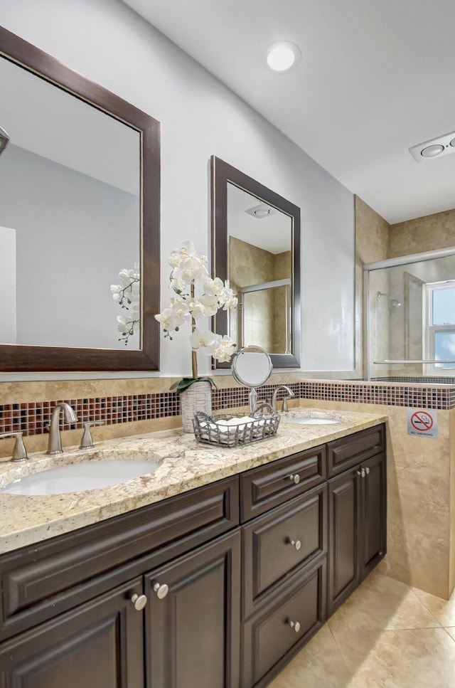 bathroom featuring tile patterned flooring, a shower with door, decorative backsplash, and vanity