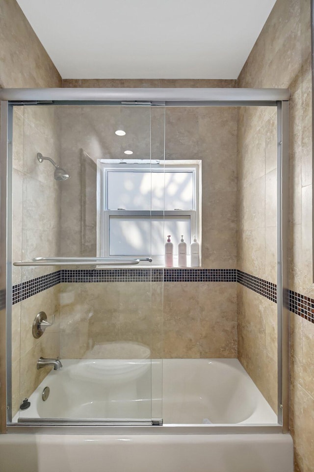 bathroom featuring bath / shower combo with glass door