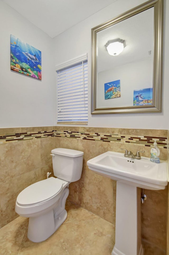 bathroom with tile walls, sink, tile patterned floors, and toilet