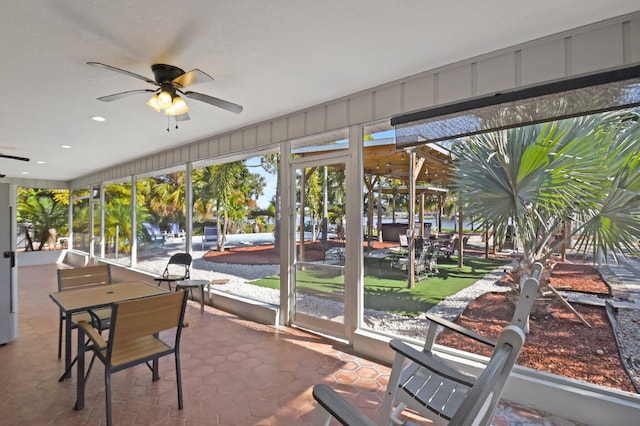 sunroom / solarium featuring ceiling fan