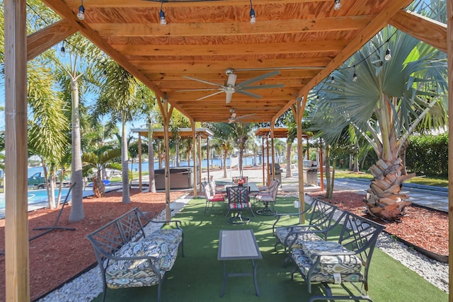 view of patio / terrace featuring ceiling fan and a hot tub