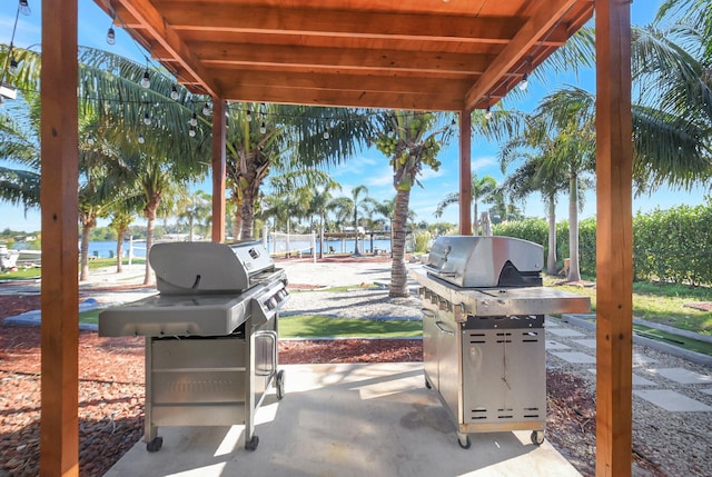 view of patio with a grill and a water view