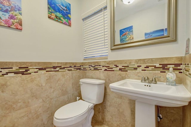 bathroom featuring tile walls and toilet