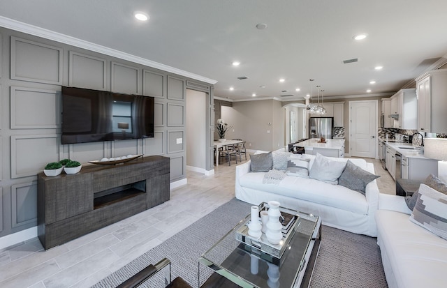 living room with ornamental molding and sink