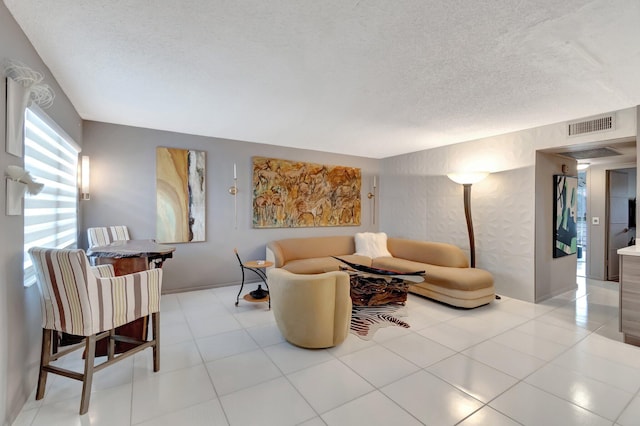 living room with a textured ceiling and light tile patterned floors