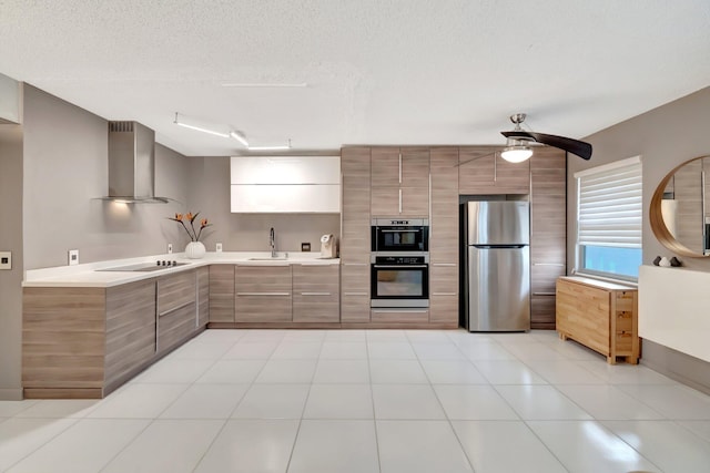 kitchen with stainless steel appliances, sink, a textured ceiling, ceiling fan, and wall chimney range hood