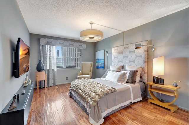 bedroom with a textured ceiling and hardwood / wood-style floors