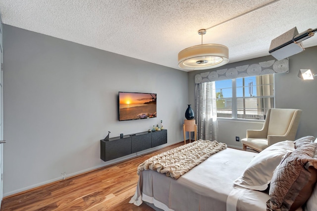 bedroom with a textured ceiling and hardwood / wood-style floors