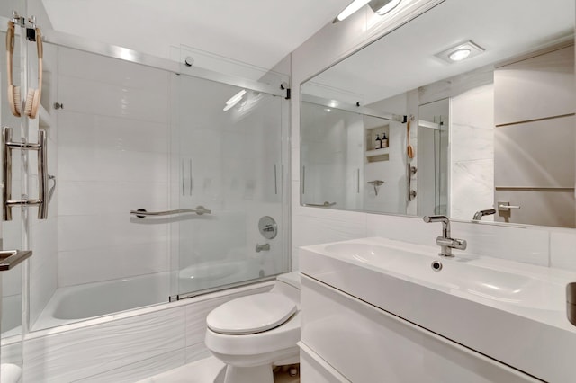 full bathroom featuring toilet, vanity, and combined bath / shower with glass door