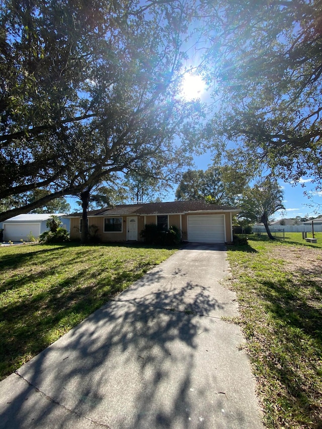 ranch-style house featuring a front yard and a garage