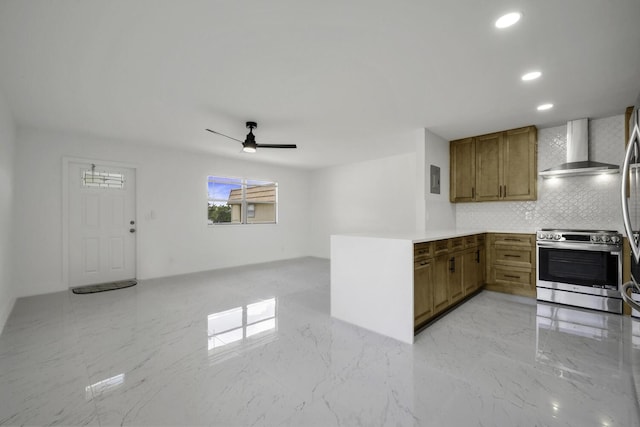 kitchen with decorative backsplash, wall chimney range hood, electric range, and ceiling fan