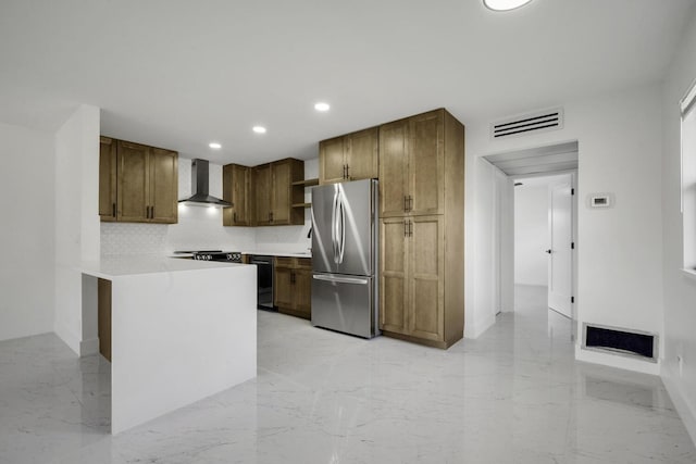 kitchen featuring dishwasher, wall chimney exhaust hood, range, stainless steel fridge, and backsplash