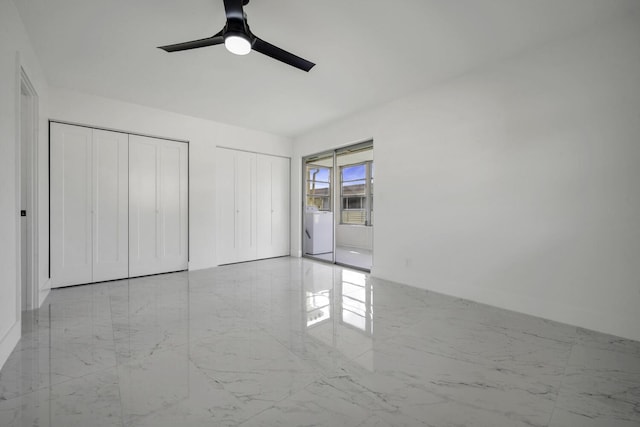 unfurnished bedroom featuring washer / clothes dryer, multiple closets, and ceiling fan