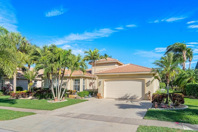 mediterranean / spanish-style house featuring a front yard and a garage