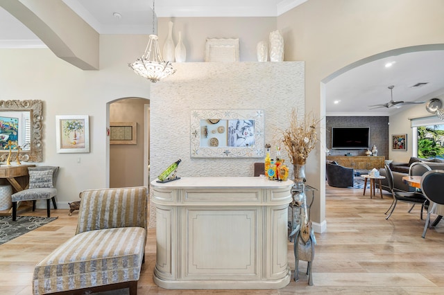 interior space with light wood-type flooring, crown molding, and a notable chandelier