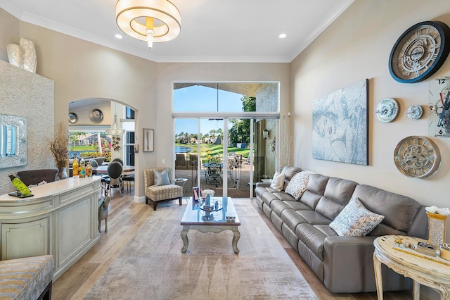 living room with ornamental molding and light hardwood / wood-style flooring