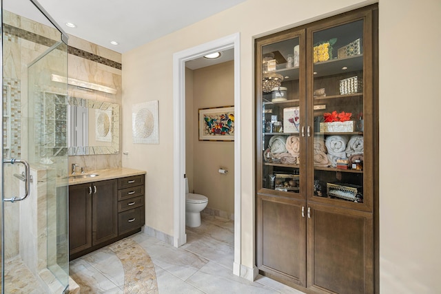 bathroom featuring toilet, an enclosed shower, and vanity