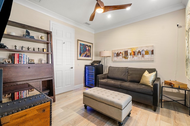 living room featuring crown molding, light hardwood / wood-style floors, and ceiling fan