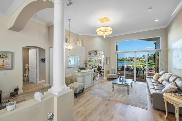 living room featuring decorative columns, light hardwood / wood-style flooring, and ornamental molding