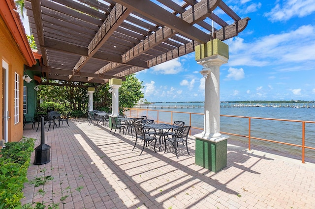 view of patio / terrace featuring a pergola and a water view