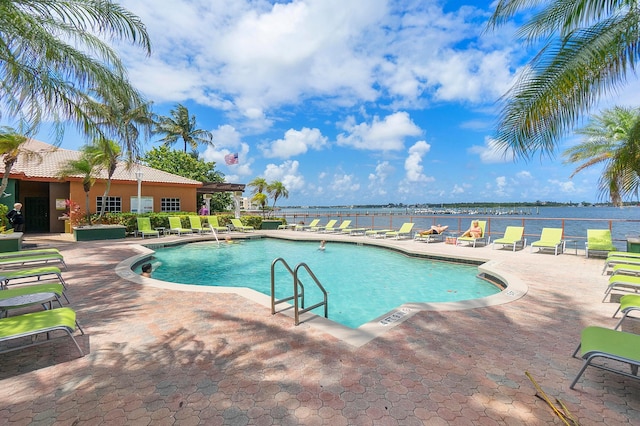 view of pool with a patio and a water view