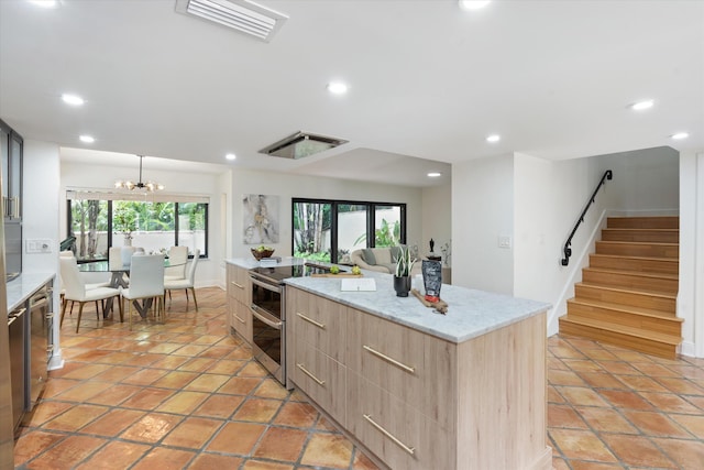 kitchen featuring stainless steel appliances, light tile patterned flooring, a wealth of natural light, and a kitchen island